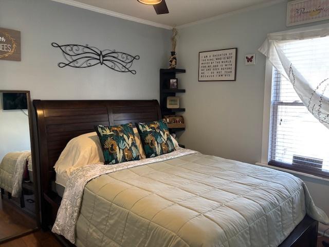 bedroom with ceiling fan and ornamental molding