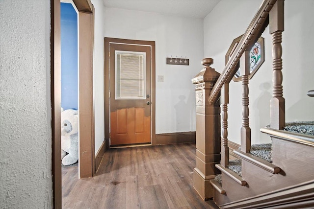 interior space with stairs, baseboards, and wood finished floors