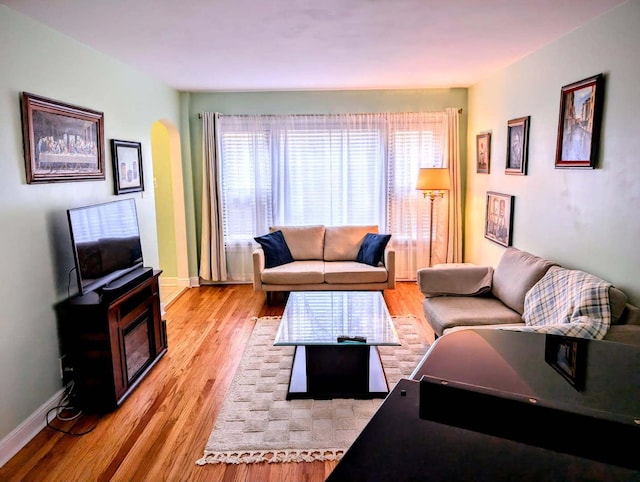 living area featuring light wood-type flooring and baseboards