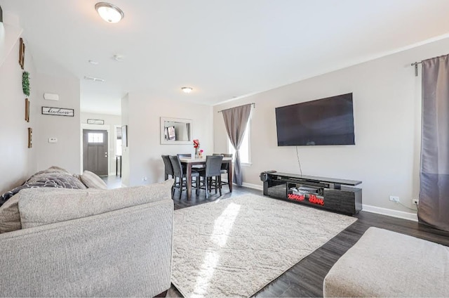 living room with dark hardwood / wood-style flooring and plenty of natural light