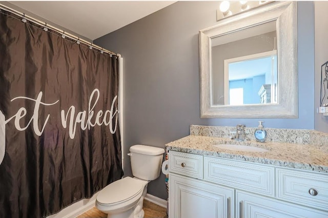 bathroom featuring a shower with shower curtain, vanity, and toilet