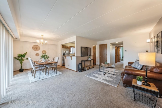 carpeted living area featuring baseboards and a notable chandelier