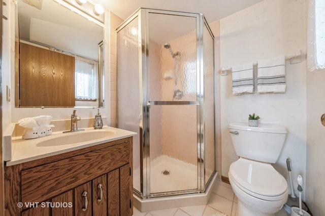 bathroom featuring toilet, a stall shower, and vanity