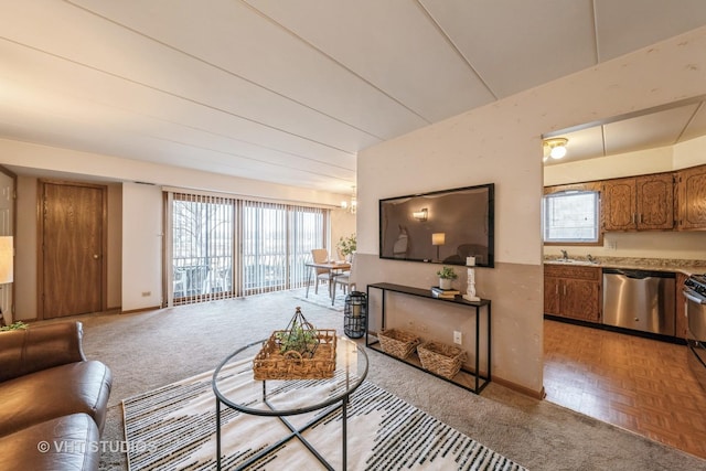 living room featuring a wealth of natural light, baseboards, and an inviting chandelier