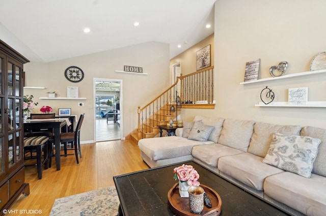 living area featuring vaulted ceiling, stairway, light wood-style flooring, and recessed lighting