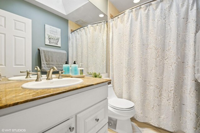 full bathroom featuring toilet, vanity, and tile patterned floors