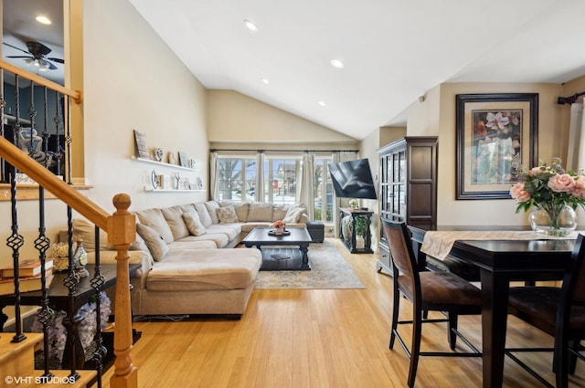 living room featuring ceiling fan, high vaulted ceiling, recessed lighting, light wood-style floors, and stairs