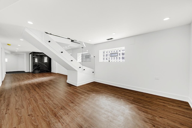 unfurnished living room with baseboards, visible vents, dark wood finished floors, and recessed lighting