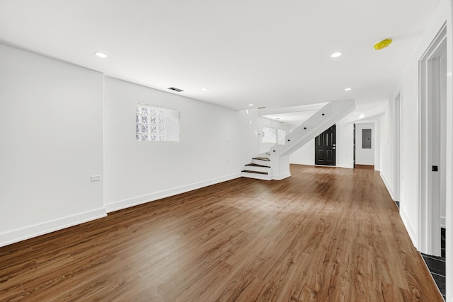 unfurnished living room featuring baseboards, visible vents, wood finished floors, stairs, and recessed lighting