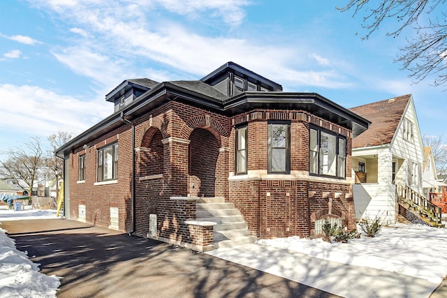 view of front of home featuring brick siding and stairway