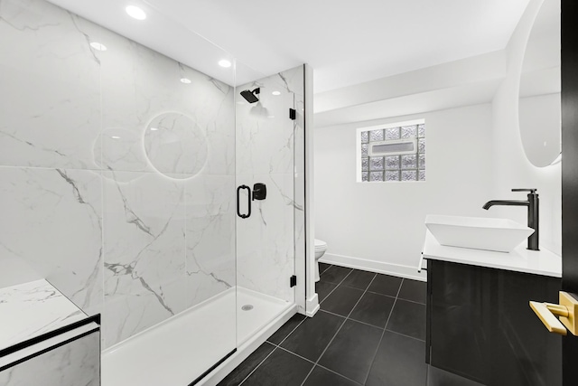 full bath with double vanity, a marble finish shower, baseboards, toilet, and a sink