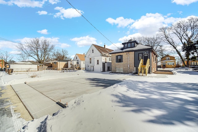 exterior space featuring a residential view, brick siding, and fence