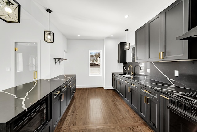 kitchen featuring a sink, backsplash, dark wood-style floors, black appliances, and pendant lighting