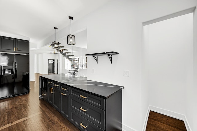 kitchen with black fridge with ice dispenser, dark wood-type flooring, hanging light fixtures, dark cabinetry, and open shelves