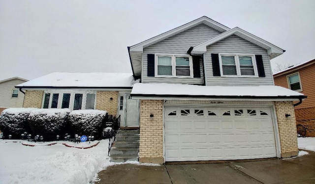 tri-level home with brick siding, driveway, and a garage