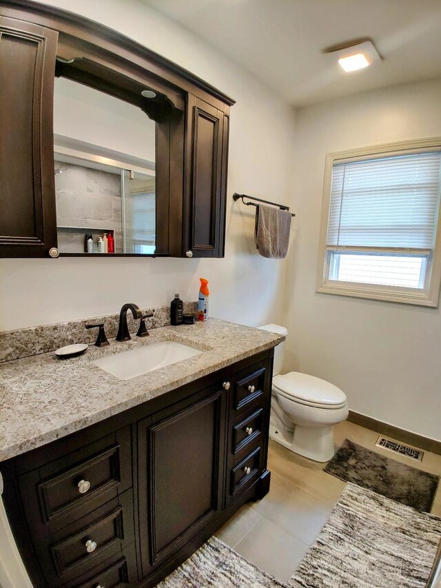 bathroom featuring visible vents, toilet, vanity, and tile patterned flooring