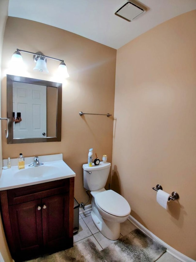 half bathroom featuring visible vents, baseboards, toilet, tile patterned floors, and vanity