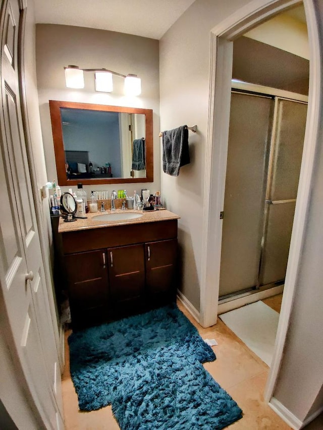 bathroom featuring baseboards, vanity, and a shower stall