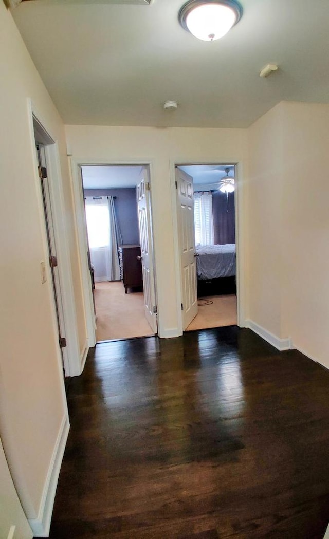 corridor featuring wood finished floors and baseboards