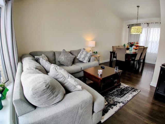 living area featuring baseboards, lofted ceiling, and dark wood finished floors