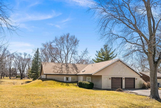 view of property exterior featuring an attached garage, driveway, and a yard