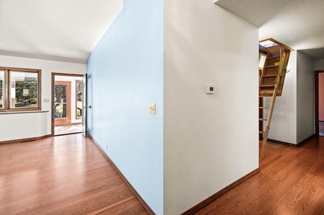 hallway featuring wood finished floors and baseboards