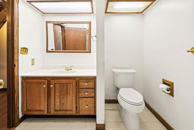 bathroom with vanity, tile patterned floors, toilet, and baseboards