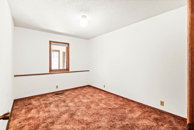 unfurnished room featuring baseboards, visible vents, a textured ceiling, and carpet