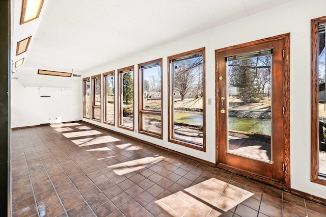 unfurnished sunroom with a water view