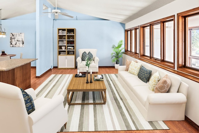 living area featuring vaulted ceiling, light wood-style flooring, and ceiling fan