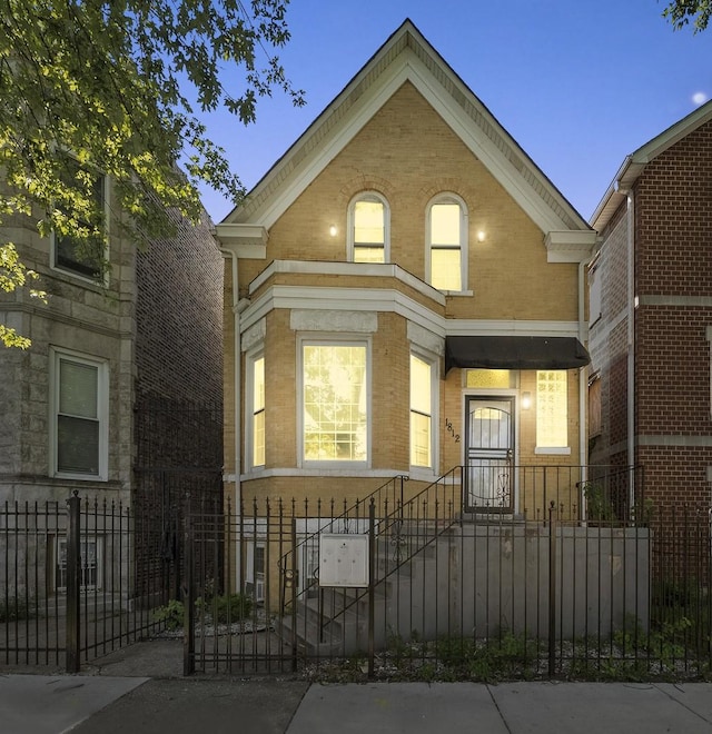 view of front of property featuring a fenced front yard and brick siding