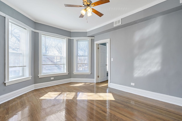 unfurnished room with wood finished floors, plenty of natural light, a ceiling fan, and baseboards