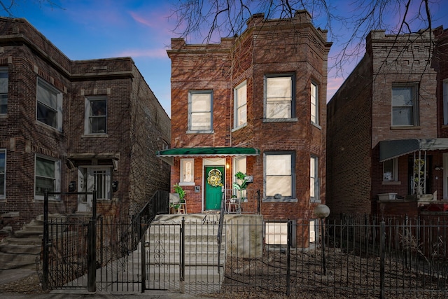 view of front facade with a fenced front yard and brick siding