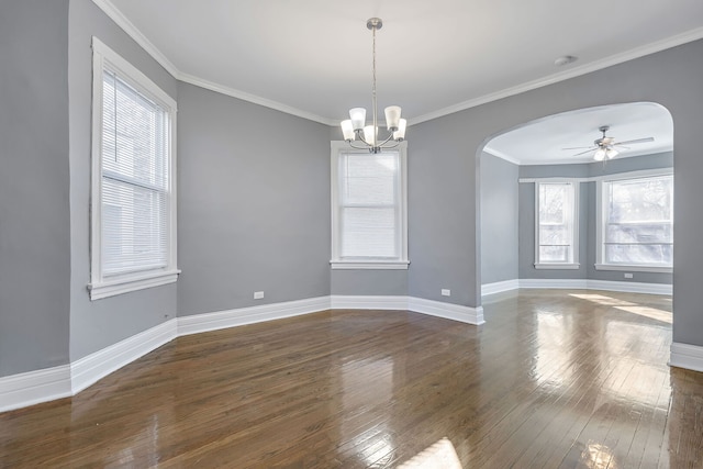 spare room featuring baseboards, dark wood-style floors, arched walkways, and ornamental molding