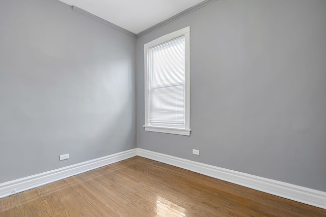 unfurnished room with baseboards, wood finished floors, and ornamental molding