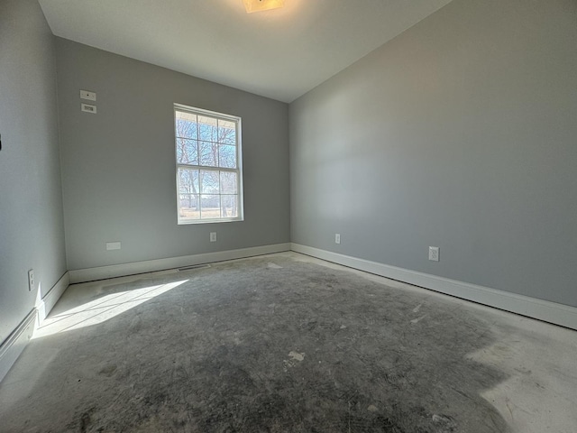 unfurnished room featuring baseboards and unfinished concrete floors