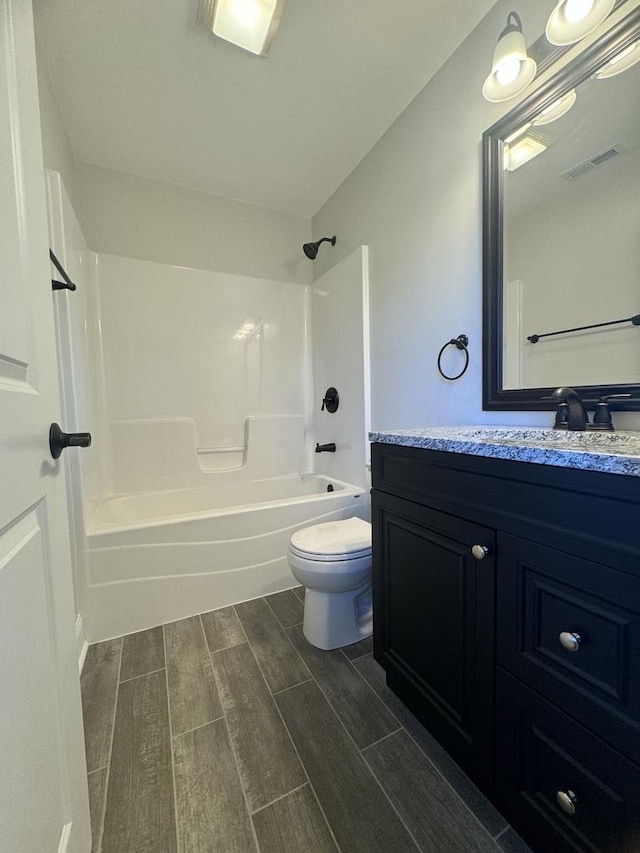 bathroom with visible vents, toilet, wood tiled floor, tub / shower combination, and vanity