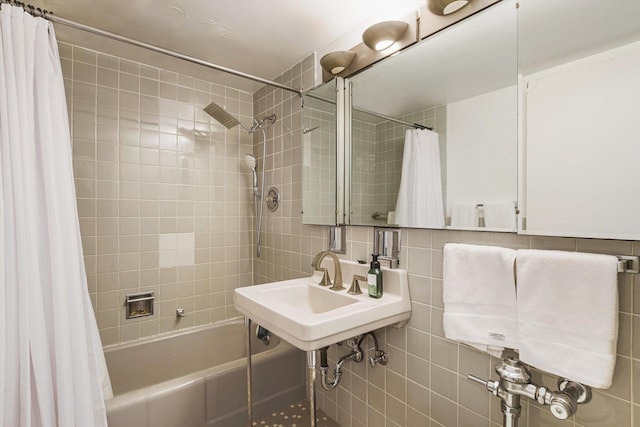 full bath with shower / bath combo, a sink, tile walls, and decorative backsplash