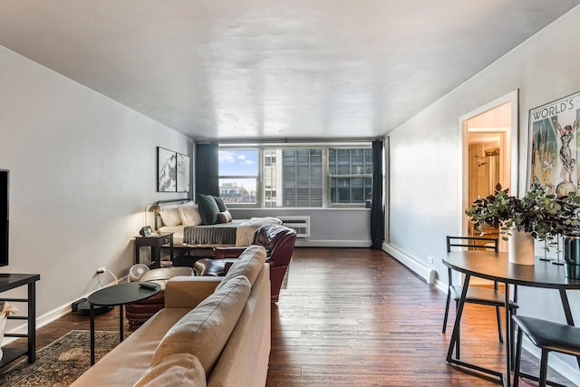 living area featuring dark wood-style floors, a wall mounted air conditioner, baseboards, and baseboard heating