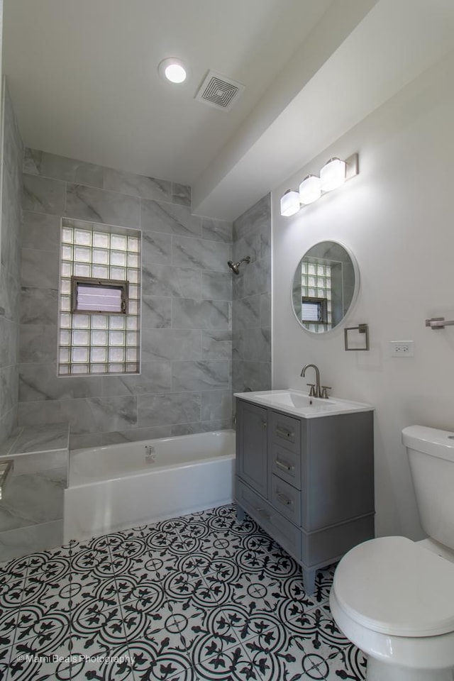 bathroom featuring visible vents, toilet,  shower combination, tile patterned flooring, and vanity