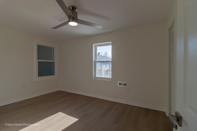 unfurnished room featuring visible vents, baseboards, and wood finished floors