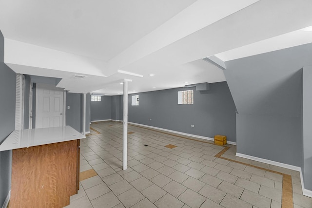 basement featuring baseboards and light tile patterned floors