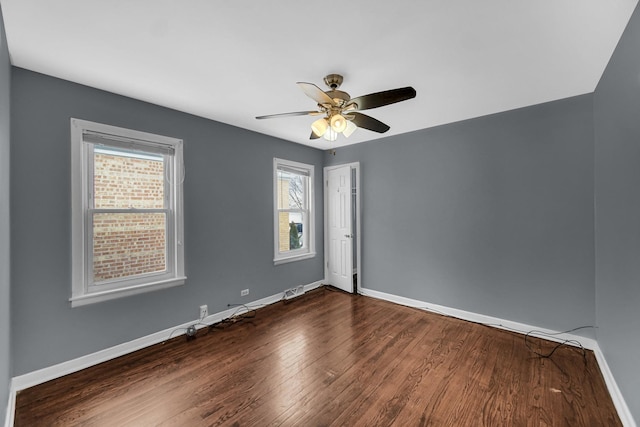 unfurnished room with a ceiling fan, dark wood-style flooring, and baseboards