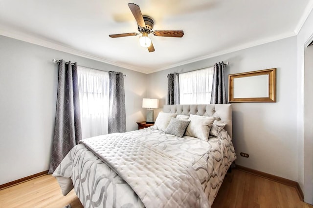 bedroom with baseboards, light wood-style floors, ornamental molding, and a ceiling fan