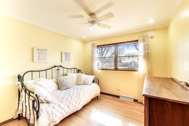 bedroom with crown molding, baseboards, visible vents, and light wood-type flooring