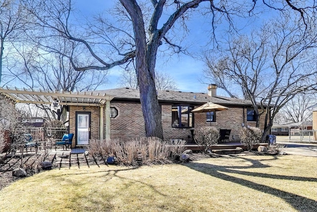 ranch-style house featuring brick siding, a pergola, and a front lawn