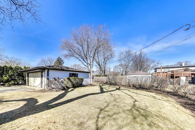 view of yard with a garage and concrete driveway