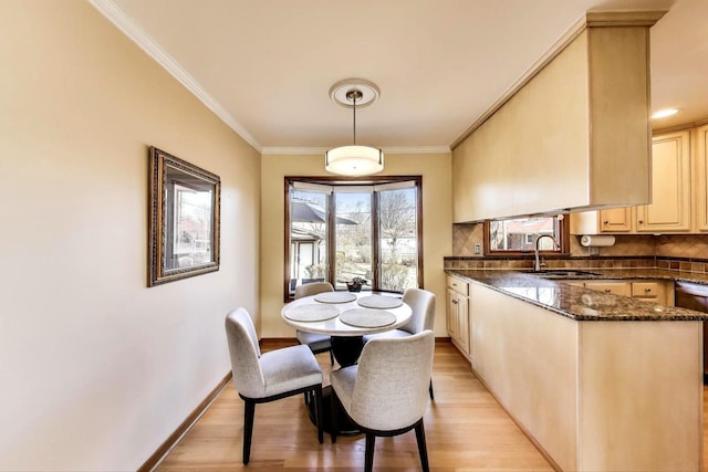 dining room with baseboards, light wood-style floors, and crown molding