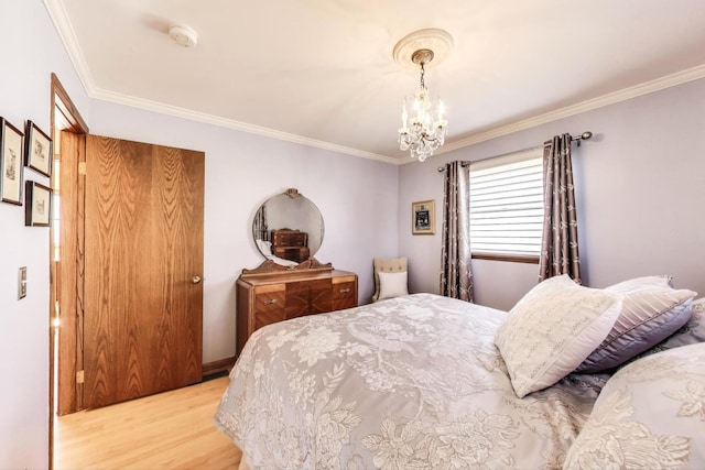 bedroom with light wood finished floors, a notable chandelier, and crown molding