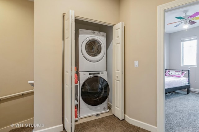 washroom featuring baseboards, laundry area, carpet flooring, and stacked washer / drying machine